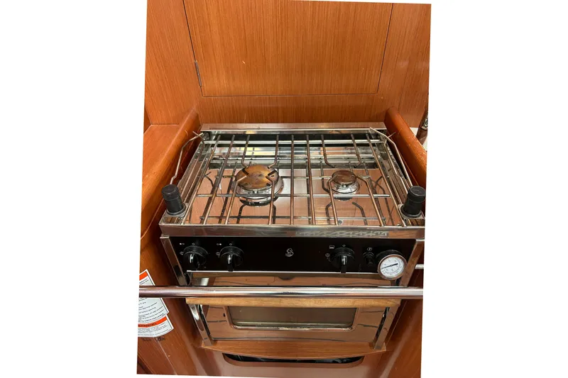 Slide: The Image of Stove and oven in 2009 Beneteau 343 yacht galley, featuring wooden cabinetry. - 26