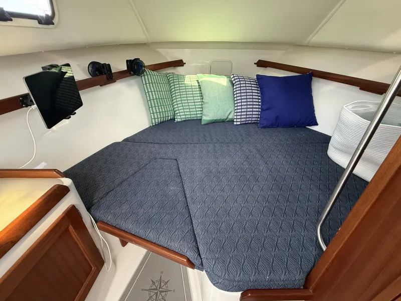 Slide: The Image of The cabin of the 2020 NorthCoast 285 HT features a cozy bed with blue cushions. - 26