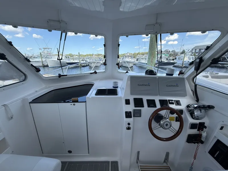 Slide: The Image of The cockpit of a 2020 NorthCoast 285 HT with modern electronics and a view of the marina. - 18