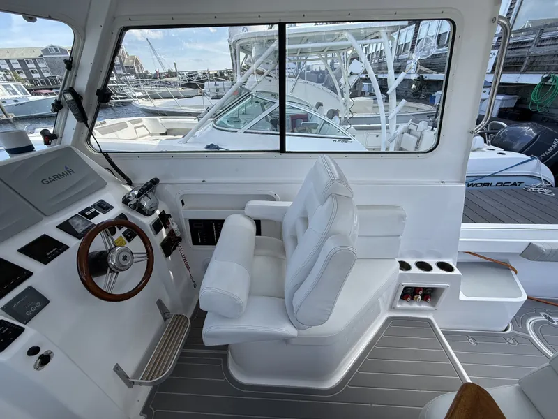 Slide: The Image of Interior of a 2020 NorthCoast 285 HT boat with white seating and steering wheel. - 16