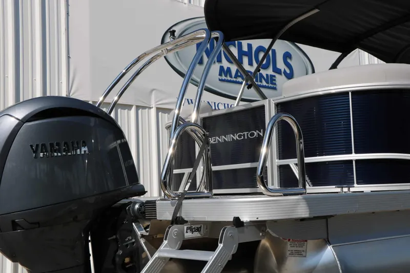 Slide: The Image of A 2027 Bennington 22 SSR Tri Toon with Yamaha engine, in front of a building with marine logo. - 22