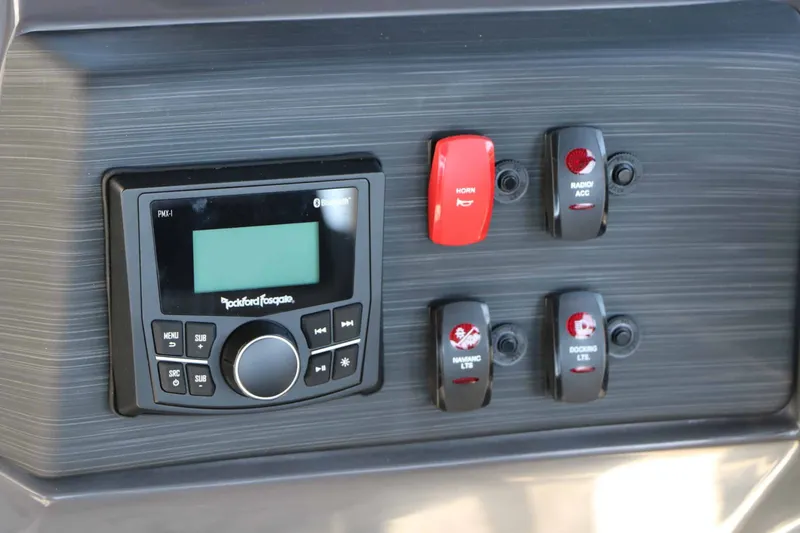 Slide: The Image of The image shows the dashboard of a Bennington 22 SSR Tri Toon with various switches and a radio. - 39