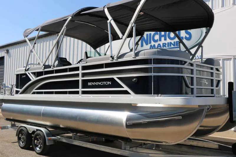 Slide: The Image of A 2027 Bennington 22 SSR Tri Toon on a trailer. It features a black canopy. - 4