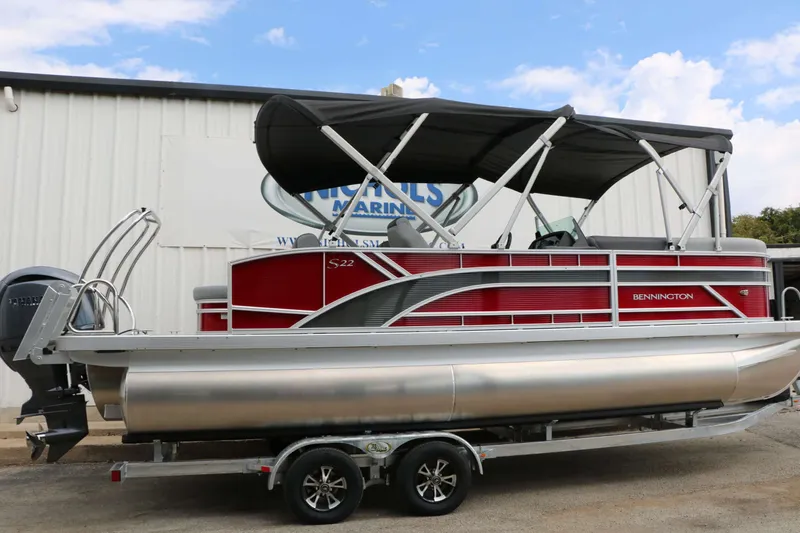 Slide: The Image of A red 2027 Bennington 22 SSB Tri Toon on a trailer in front of a building. - 12