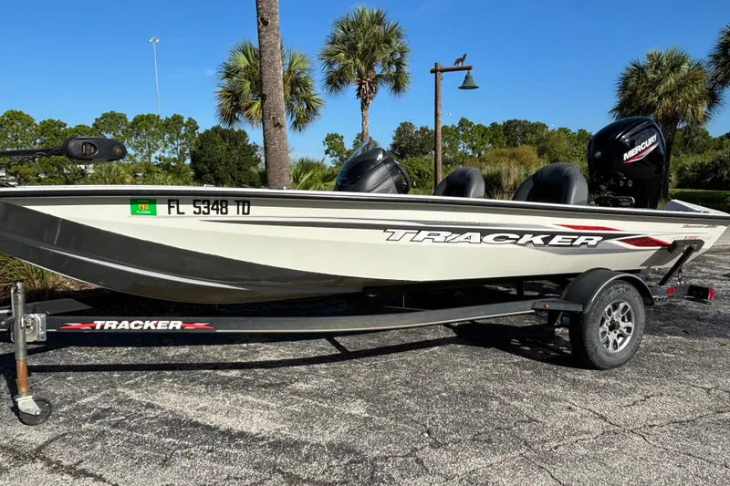 The Image of 2022 Tracker Pro Team 175 TF boat on trailer, parked outdoors with palm trees. - 0