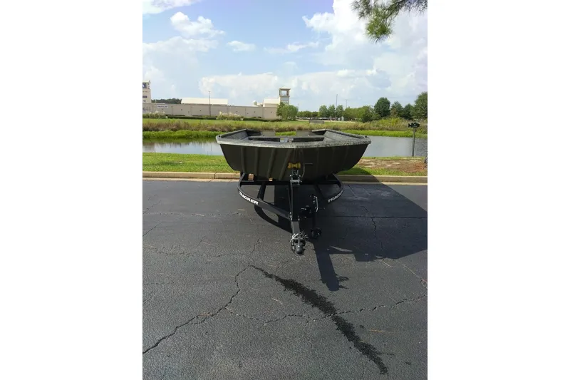 The Image of 2026 Tracker Grizzly 2072 Utility boat on trailer, parked near a scenic pond. - 9
