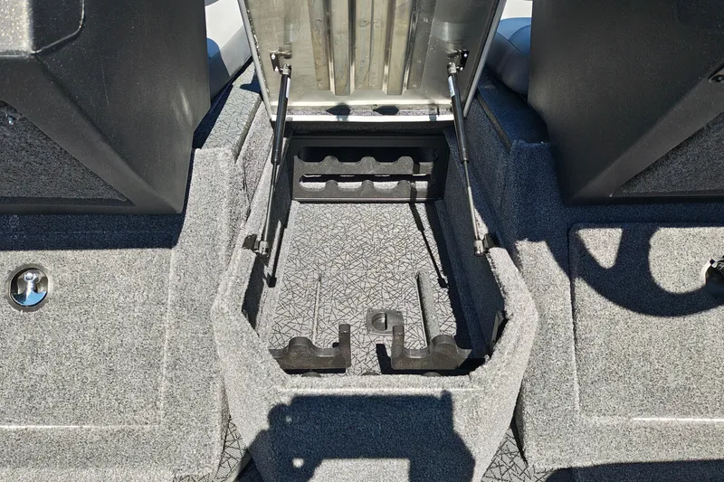Slide: The Image of 2027 Tracker Pro Guide V-175 Combo boat storage compartment with open lid and carpeted interior. - 24