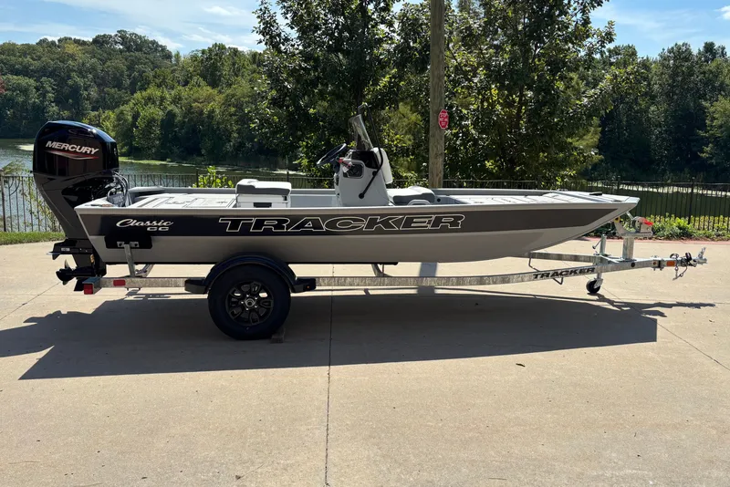 The Image of 2027 Tracker Bass Tracker Classic CC boat on trailer, parked near a scenic lake. - 0
