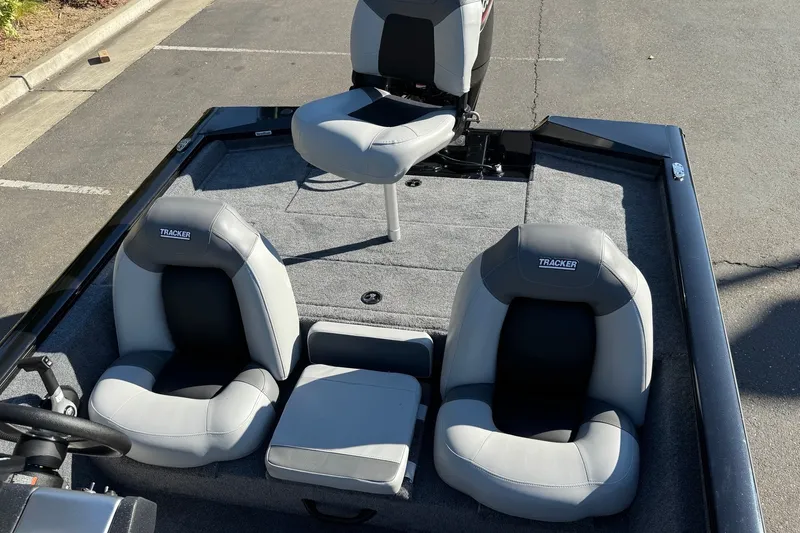 Slide: The Image of 2027 Tracker Pro Team 175 boat interior with three gray seats on a sunny day. - 13