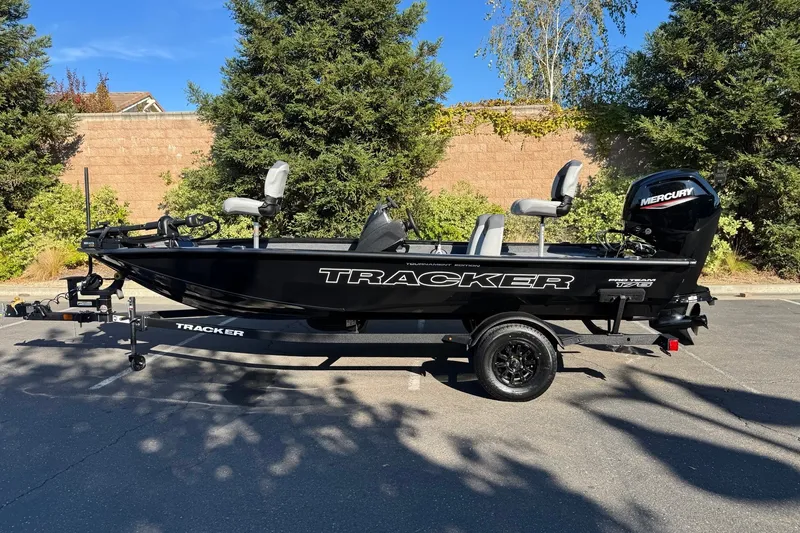 The Image of 2027 Tracker Pro Team 175 boat with Mercury engine, parked outdoors on a sunny day. - 0