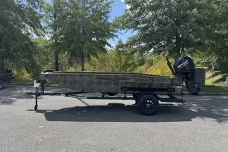The Image of 2027 Tracker Grizzly 1650 T Prairie Wings Edition boat on trailer, parked outdoors. - 0