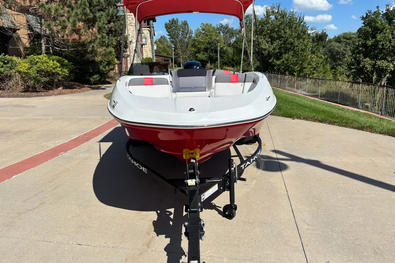 Slide: The Image of 2027 Tahoe T16 boat on trailer, red and white design, parked outdoors. - 2