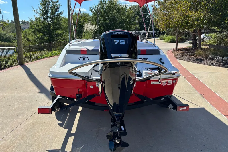 Slide: The Image of Red 2027 Tahoe T16 boat with Mercury 75 engine on a trailer, parked outdoors. - 1