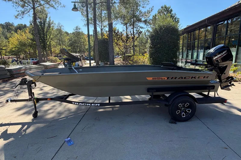 The Image of 2027 Tracker Grizzly 1756 T Marsh boat on trailer, outdoors in a wooded area. - 0