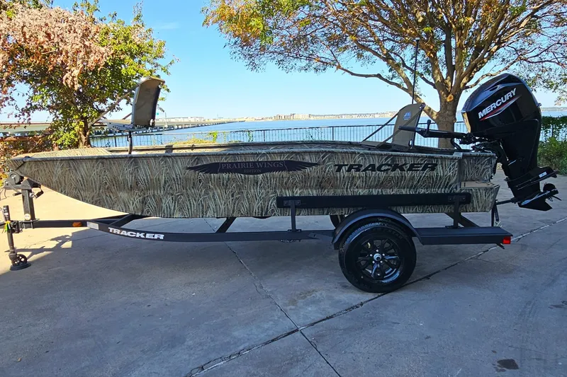 The Image of 2027 Tracker Grizzly 1650 T Prairie Wings Edition boat on trailer by waterfront. - 0