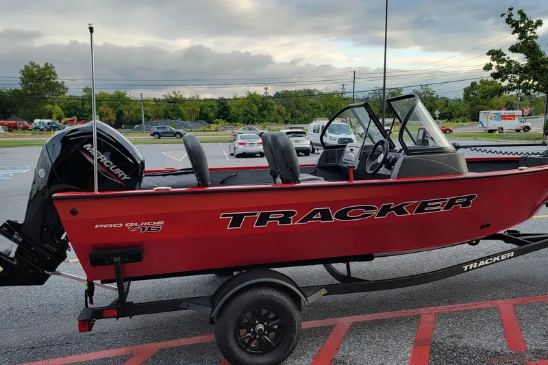 The Image of 2026 Tracker Pro Guide V-16 WT boat on trailer in parking lot. - 0
