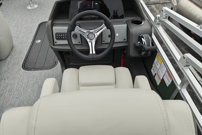 Slide: The Image of 2027 Sun Tracker Fishin' Barge 22 XP3 helm with steering wheel and controls. - 23