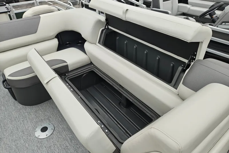 Slide: The Image of 2027 Sun Tracker Fishin' Barge 22 XP3 boat with open storage compartment and cushioned seating. - 18