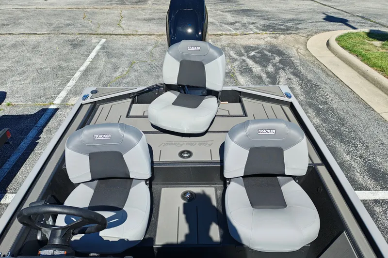 Slide: The Image of 2027 Tracker Pro 170 boat interior with three gray seats in a parking lot. - 25