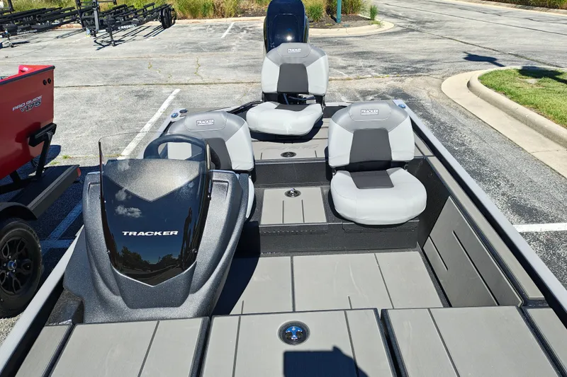 Slide: The Image of 2027 Tracker Pro 170 boat with gray seating and sleek design in a parking lot. - 24