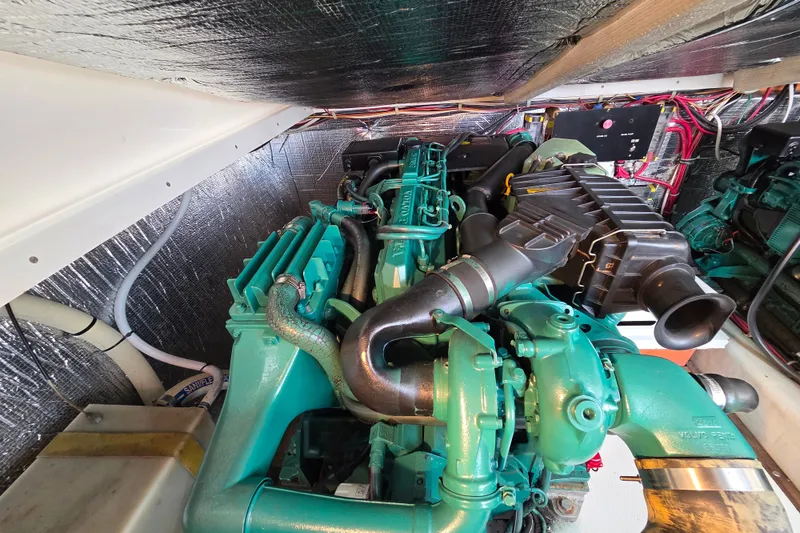 Slide: The Image of Engine compartment of a 1999 Fortier Express 33 boat, showcasing detailed machinery and wiring. - 30