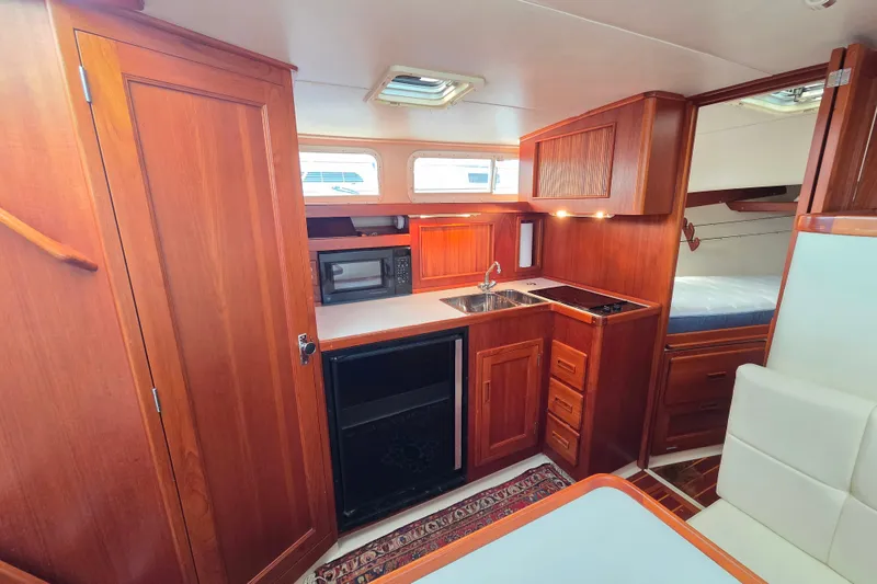 Slide: The Image of Interior of 1999 Fortier Express 33 yacht with wooden cabinetry and compact kitchen area. - 21