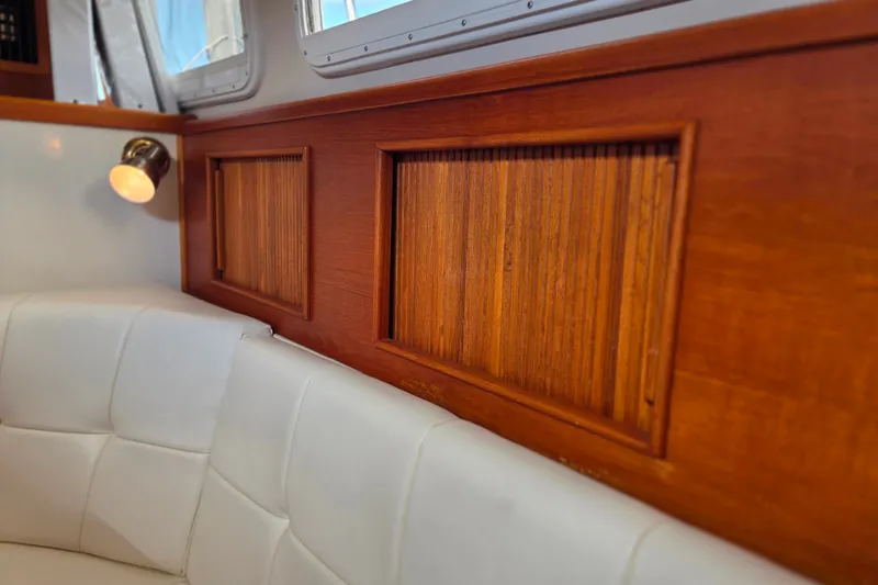 Slide: The Image of Interior of 1999 Fortier Express 33 with wood paneling and white cushioned seating. - 22