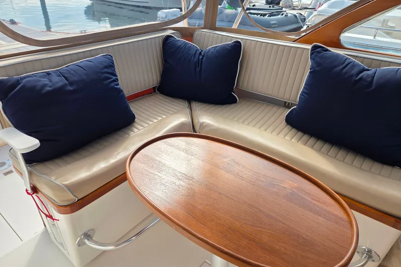 Slide: The Image of Interior of 1999 Fortier Express 33 boat with cushioned seating and wooden table. - 15