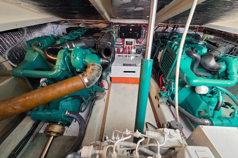 Slide: The Image of Engine room of a 1999 Fortier Express 33 boat, showcasing dual green engines. - 28