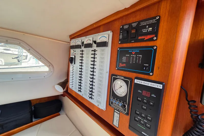 Slide: The Image of Control panel of a 1999 Fortier Express 33 boat, featuring gauges and switches. - 23