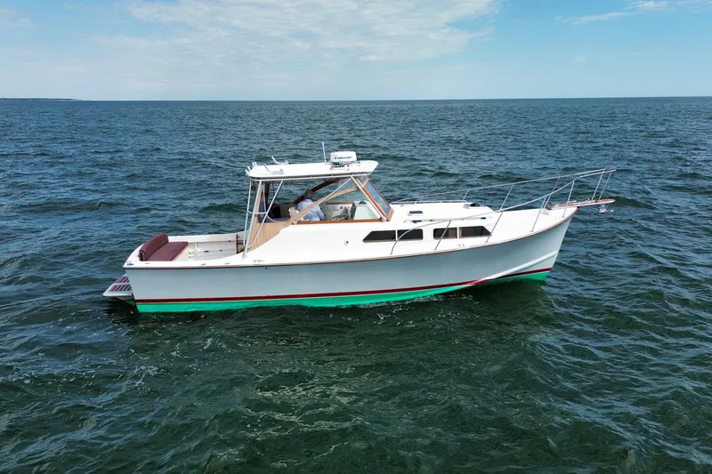 The Image of 1999 Fortier Express 33 boat cruising on open water under a clear sky. - 0