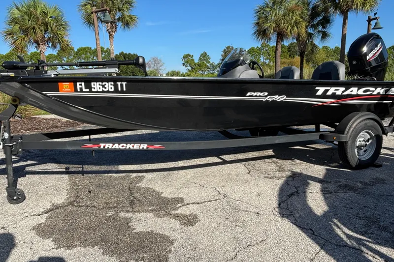 The Image of 2024 Tracker Pro 170 boat on trailer, parked outdoors with palm trees in background. - 0