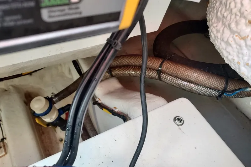 Slide: The Image of Interior view of a 2018 Cobia 220 Center Console boat showing wiring and hoses. - 14
