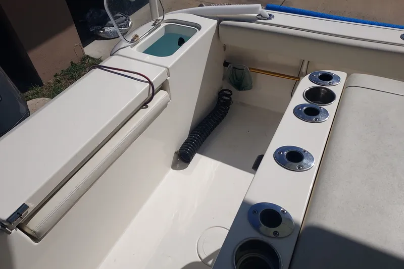 Slide: The Image of 2018 Cobia 220 Center Console boat interior with rod holders and storage compartments. - 8