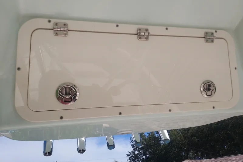 Slide: The Image of 2018 Cobia 220 Center Console storage hatch with secure latches and sleek design. - 10