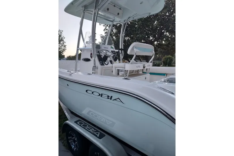 Slide: The Image of A 2018 Cobia 220 Center Console boat with a white hull and T-top. - 5