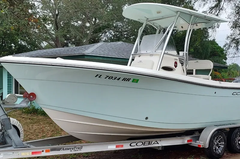Slide: The Image of 2018 Cobia 220 Center Console boat on trailer, parked outdoors. - 1