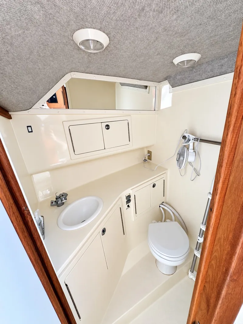 Slide: The Image of The image shows a clean, compact bathroom with a toilet, sink, and storage space. - 21