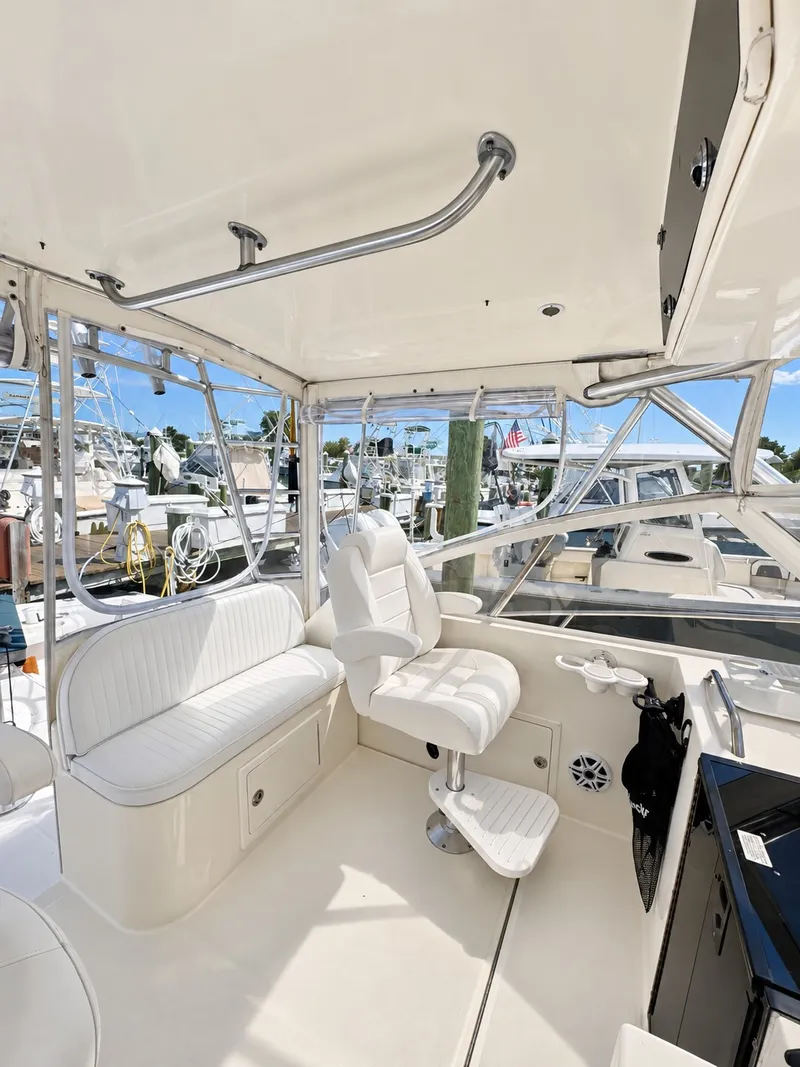 Slide: The Image of Interior of a 2005 Carolina Classic 28 Express with white seating and helm station. - 14
