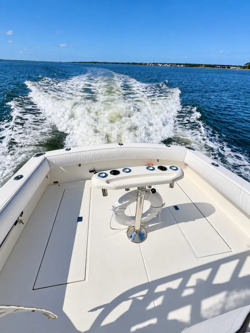 Slide: The Image of A 2005 Carolina Classic 28 Express viewed from the stern, creating a clear wake on the water. - 11