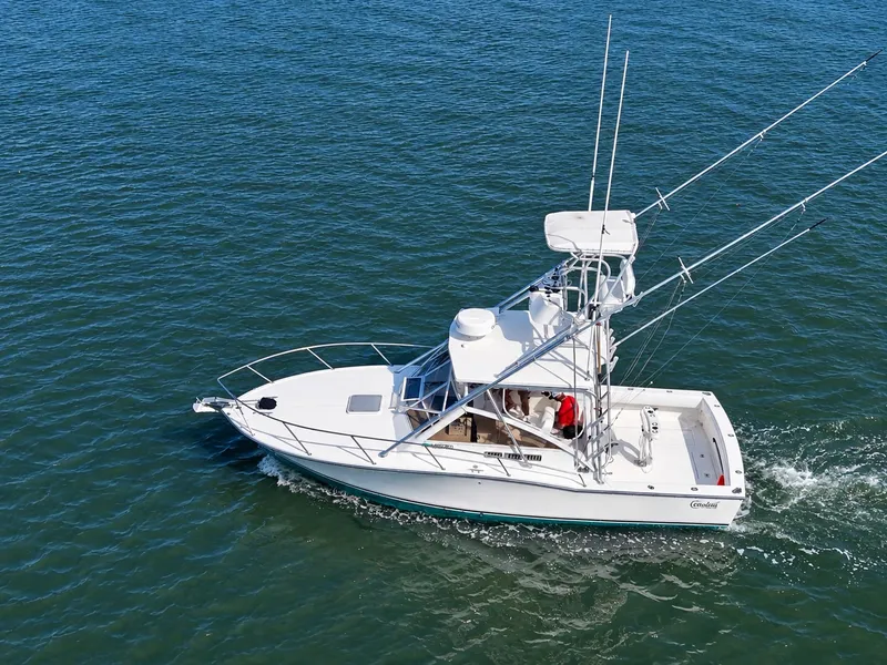 Slide: The Image of A 2005 Carolina Classic 28 Express boat cruising on calm waters. - 0