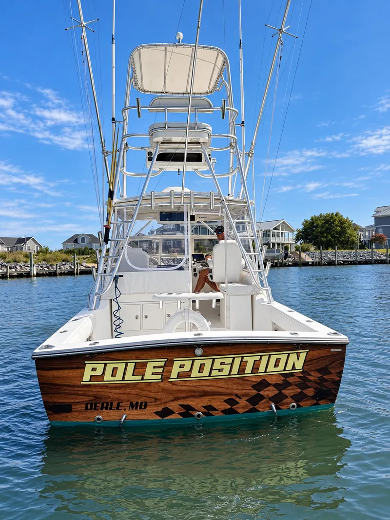Slide: The Image of A 2005 Carolina Classic 28 Express boat named "Pole Position" on the water. - 8
