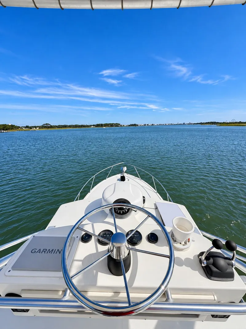 Slide: The Image of View from the helm of a Carolina Classic 28 Express overlooking the water under a blue sky. - 9