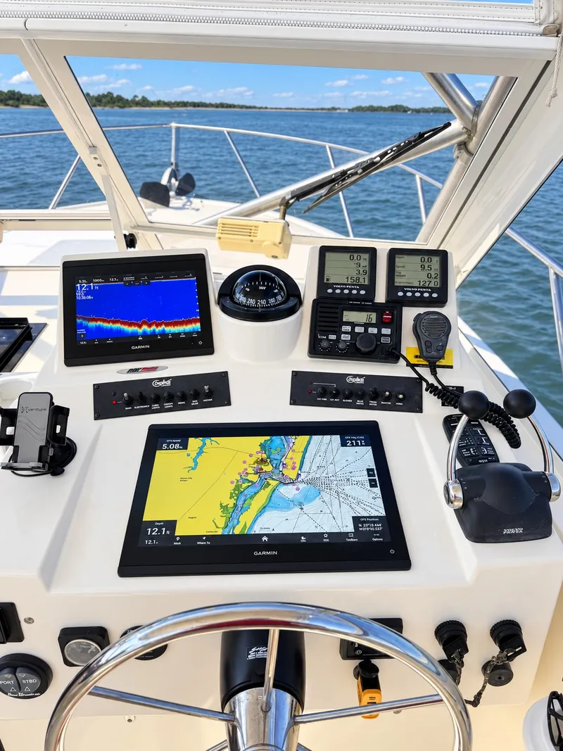 Slide: The Image of The helm of a 2005 Carolina Classic 28 Express with modern navigation equipment. - 16