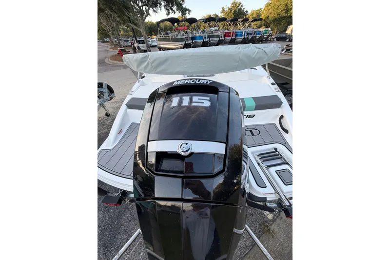 Slide: The Image of 2026 Tahoe T18 boat with Mercury 115 engine, parked outdoors. - 10