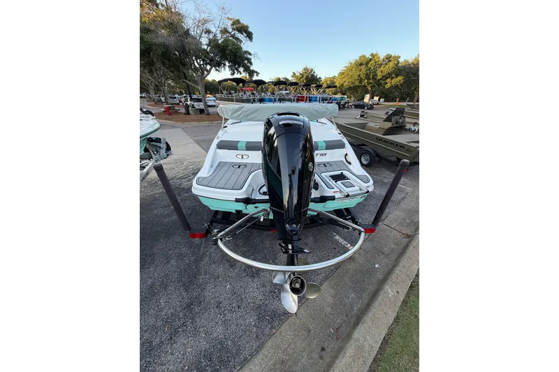 Slide: The Image of 2026 Tahoe T18 boat with outboard motor, parked on a trailer in a scenic outdoor setting. - 9