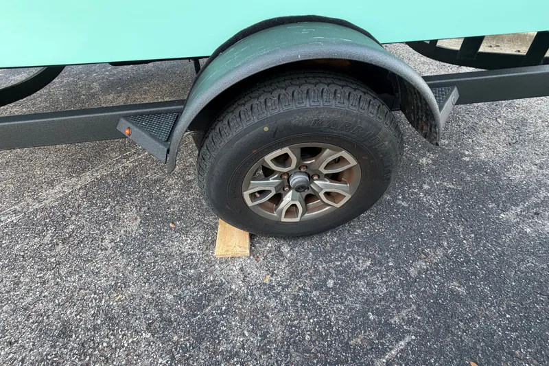 Slide: The Image of Trailer wheel of 2026 Tahoe T18 on asphalt, supported by a wooden block. - 3