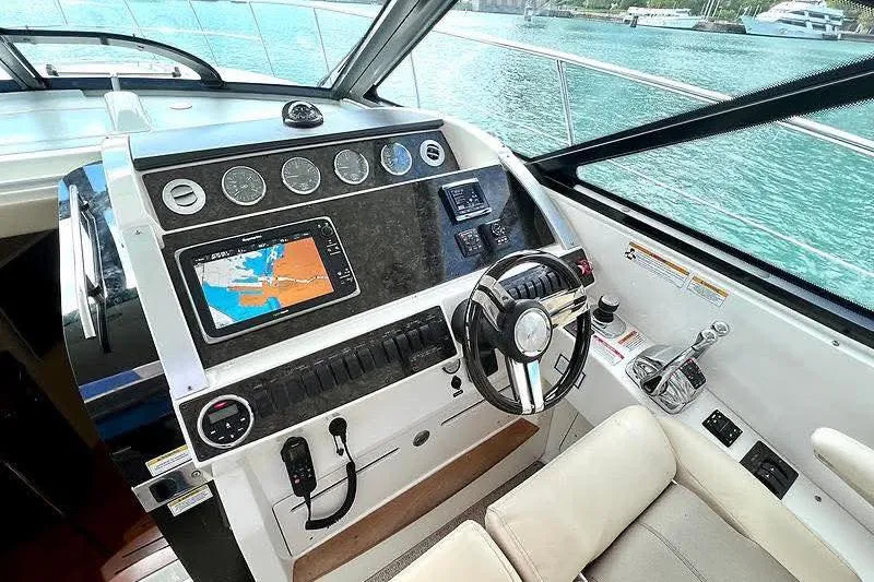 Slide: The Image of Cockpit of 2014 Sea Ray 410 Sundancer with navigation controls and steering wheel. - 15