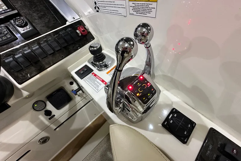 Slide: The Image of Control panel of a 2014 Sea Ray 410 Sundancer boat with throttle levers and switches. - 18