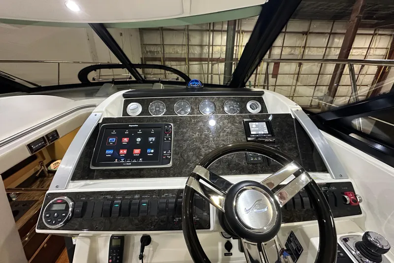 Slide: The Image of Helm of 2014 Sea Ray 410 Sundancer with modern navigation controls and sleek design. - 17